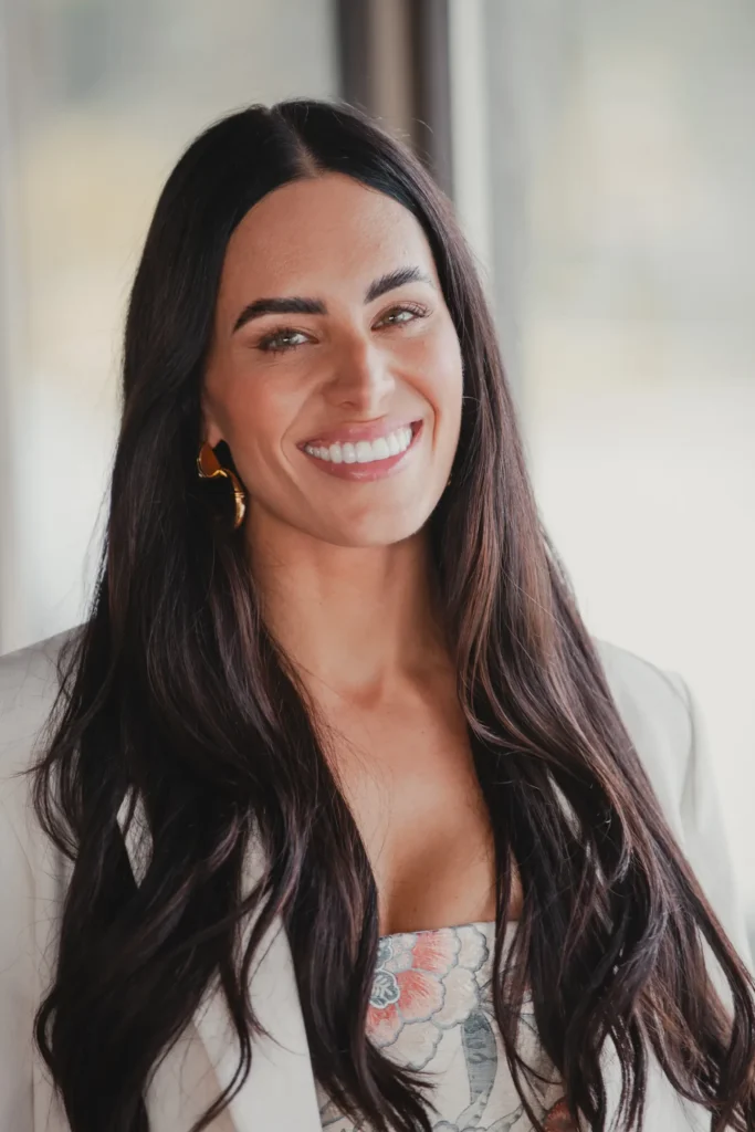 Woman with long dark hair smiling broadly