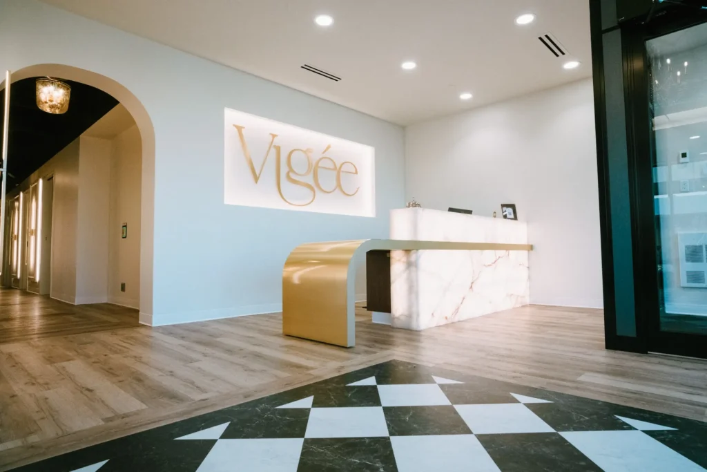 Vigée Dental reception desk with the Vigée sign and a checkered floor
