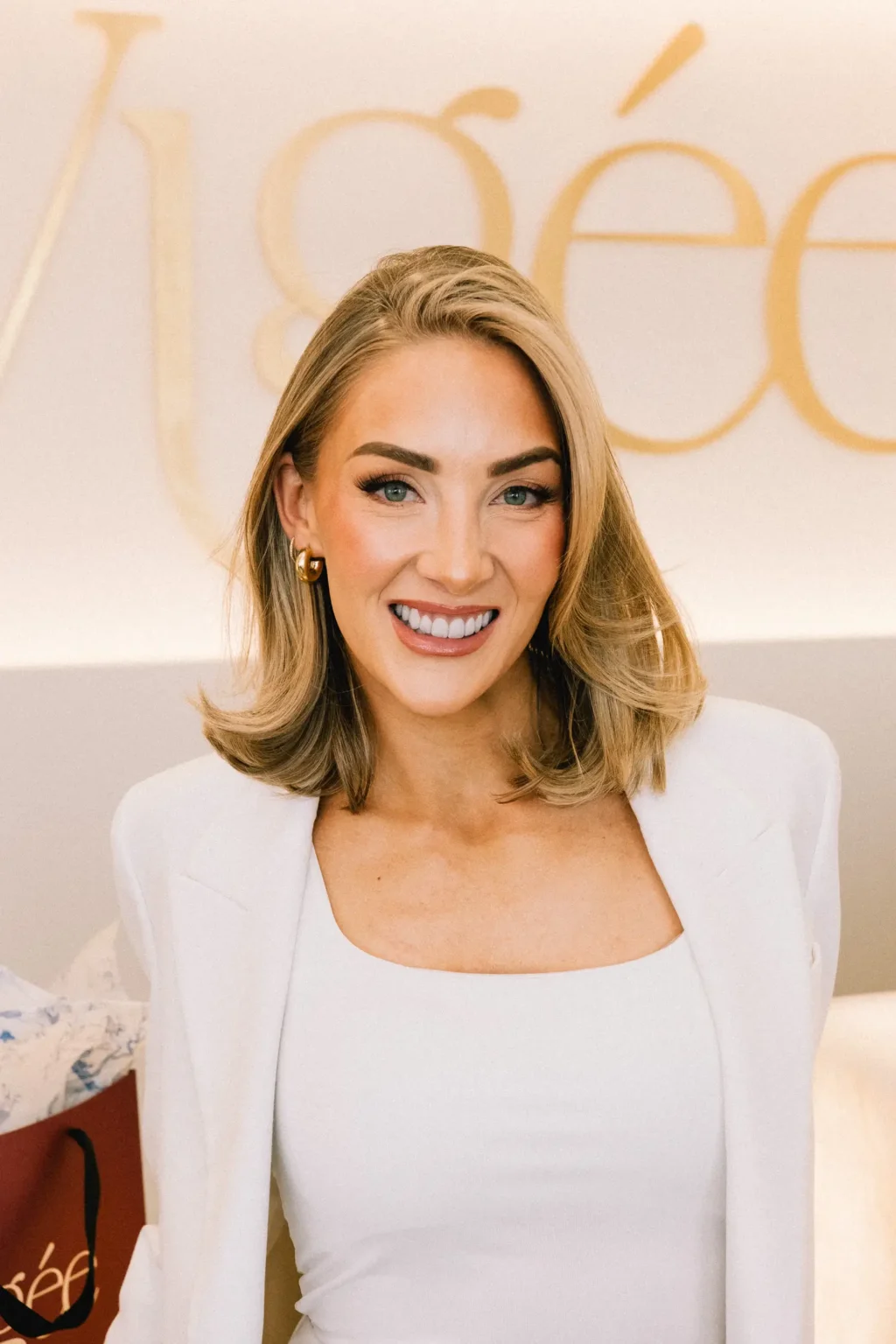 Dr. Nicole Robins smiling in front of the Vigée Dental sign